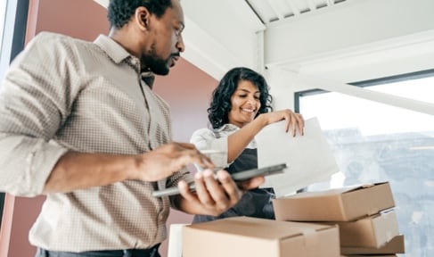 Two poeple with cardboard boxes.