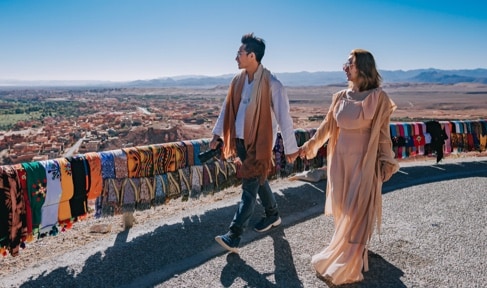 Two poeple walking holding hands.