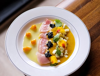 Delicately plated crudo on a bed of gazpacho
