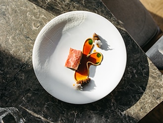 Two hands cutting into a main dish