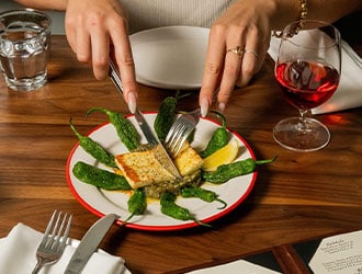 Two hands cutting into a main dish