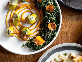 Two hands cutting into a main dish