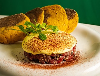 Two hands cutting into a main dish