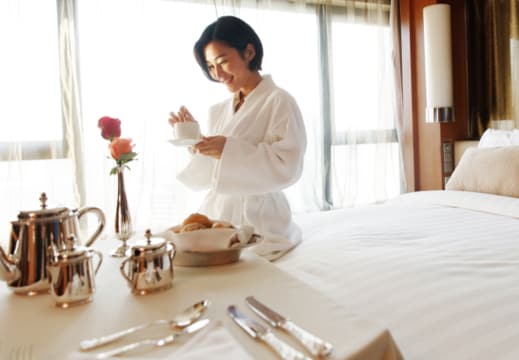 Person enjoying breakfast in hotel room.