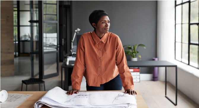 A person standing at a table with a large piece of paper