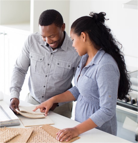 A person and person looking at a piece of fabric