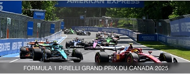 Action shot of F1 race with an American Express banner in the background.
