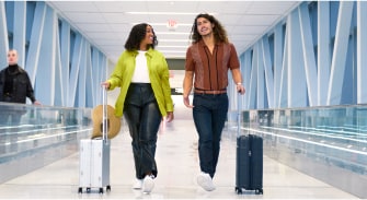 A person and person walking with luggage