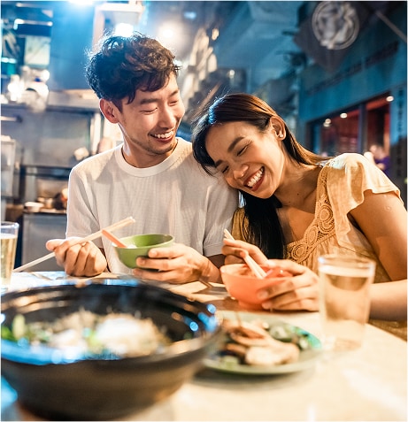 A person and person sitting at a table with food