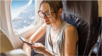 A person sitting on a plane looking at a phone