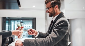 A person handing a credit card to a person