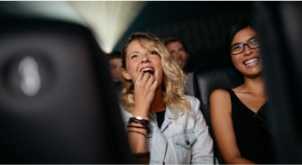 A person laughing while watching a movie