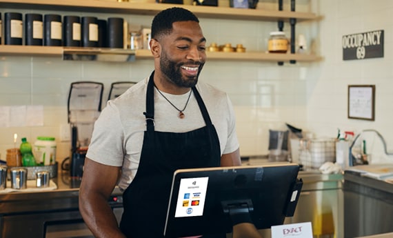 Small business owner at register behind the counter
