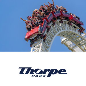 two kids running towards the camer with Warwick Castle behind them