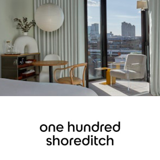 One Hundred Shoreditch. Sun shines through a large window in an upper floor hotel room. The interior decoration is modern and artistic.
