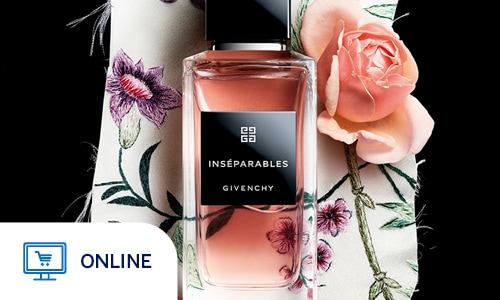 A bottle of Givenchy "Inséparables" perfume is elegantly centered atop a piece of cream-colored fabric with frayed edges. The fragrance itself has a warm, peachy-pink hue, housed in a clear glass bottle with a minimalist black label and a sleek black cap. The fabric underneath features intricate floral embroidery in shades of purple, pink, and green. A single, soft pink rose bloom rests to the right of the bottle, further emphasizing the floral and romantic theme. The entire arrangement is set against a solid black background, making the delicate textures of the embroidery and the liquid in the bottle stand out. Online only.