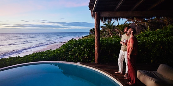 Couple looking out over pool on holiday
