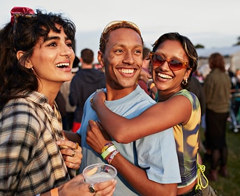 Friends smiling at an outdoor festival