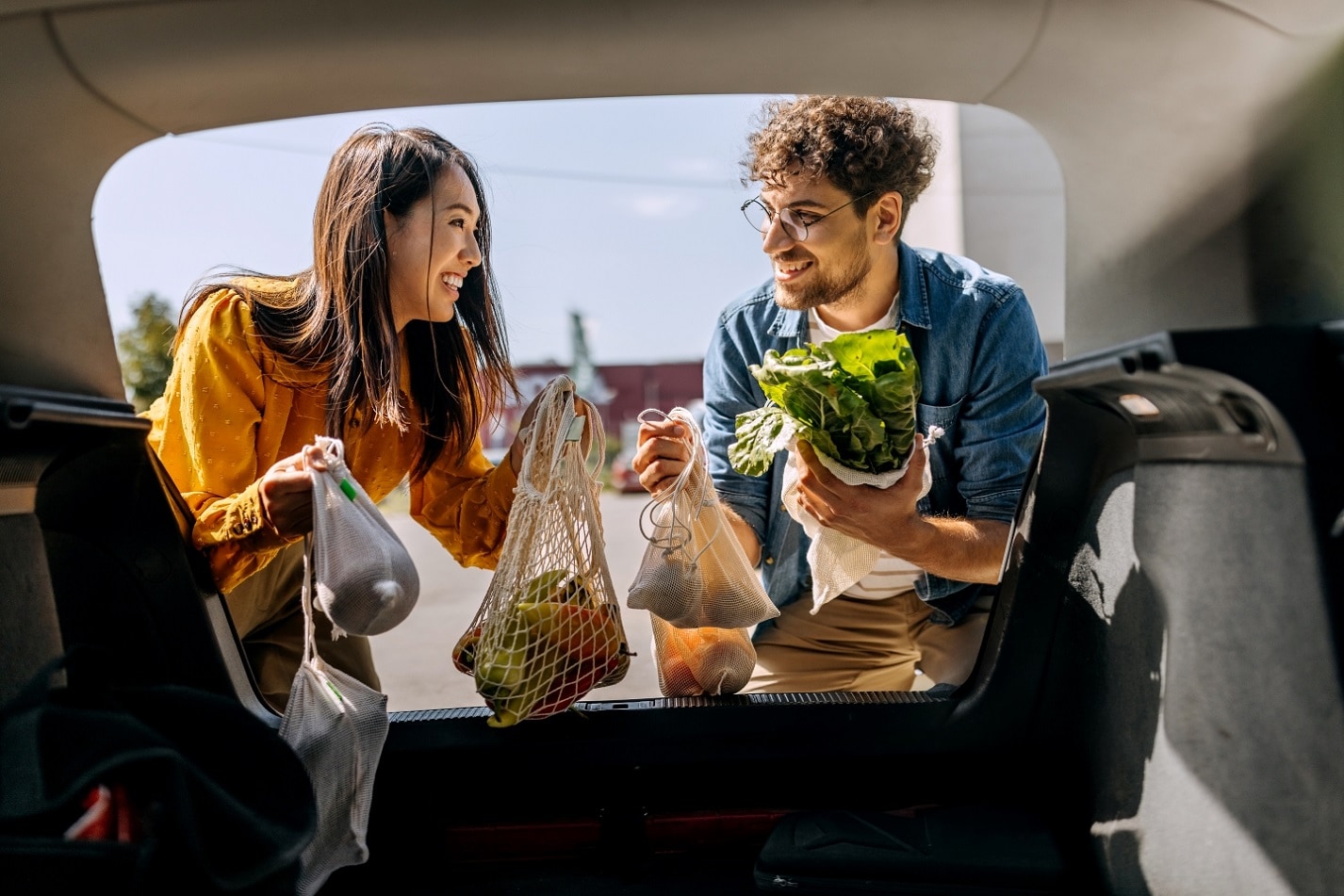 Friend loading groceries into back of car