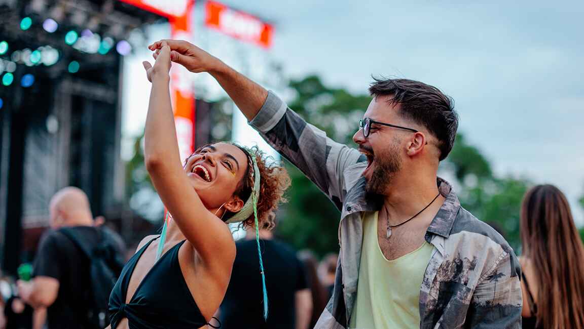 Couple are laughing in the cinema while holding popcorn and a drink