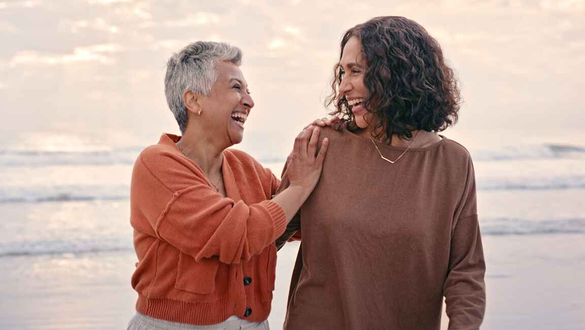 Couple are laughing on the beach at dusk