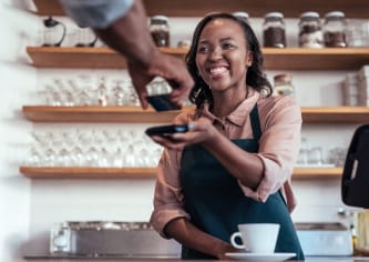 Smiling café worker with accepting payment from a customer