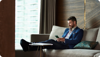 Man looking at phone on a sofa looking happy