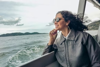Travel Accident image alt text: Woman smiling and looking out on the deck of a boat