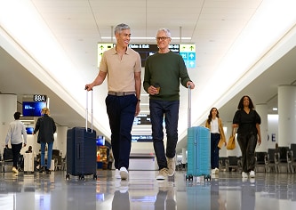 Travel Inconvenience image alt text: Older couple walking through the airport with their suitcases