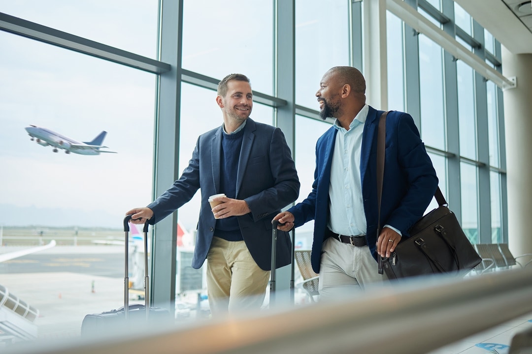 Group of professionals walking through an airport with luggage
