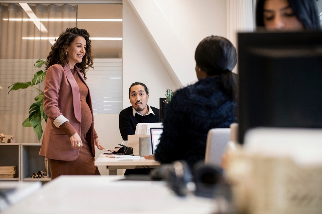 Woman talking with coworkers in a modern office