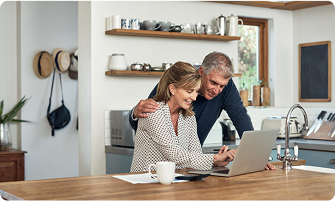 Two people at a counter, looking at a laptop