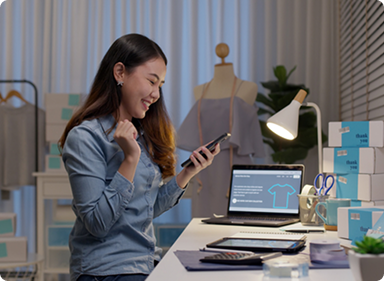 Person looks at phone while sitting at desk