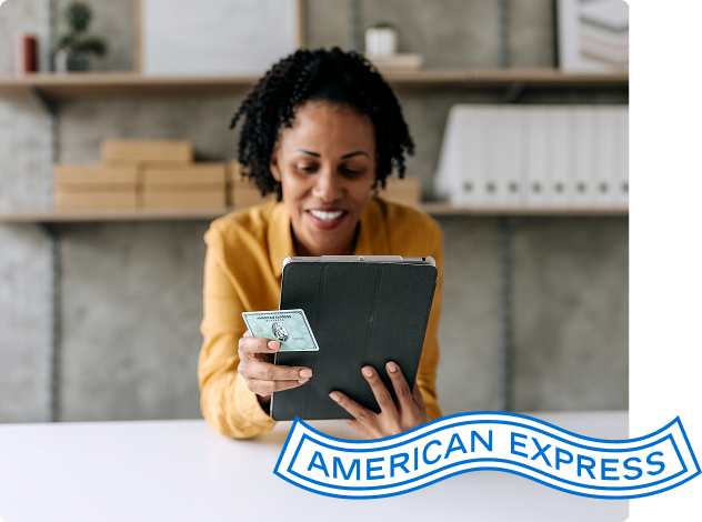 Person looks at tablet with American Express Card in hand