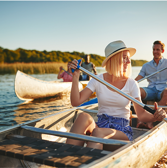 People paddle a canoe at sunset