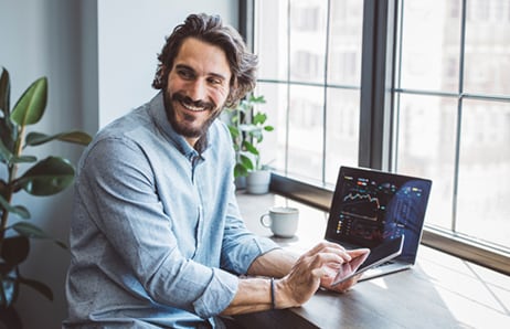 Person sits at laptop and smiles