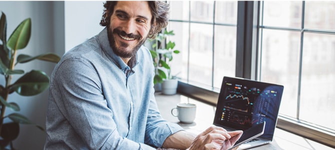 Person sits at laptop and smiles