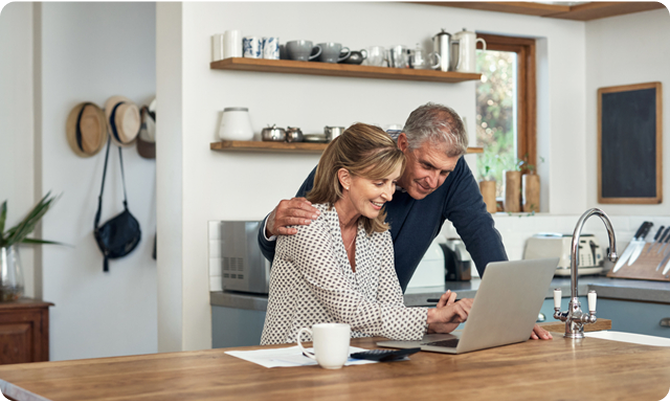 Two people at a counter, looking at a laptop