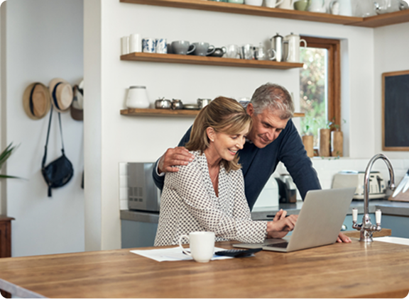 Two people at a counter, looking at a laptop