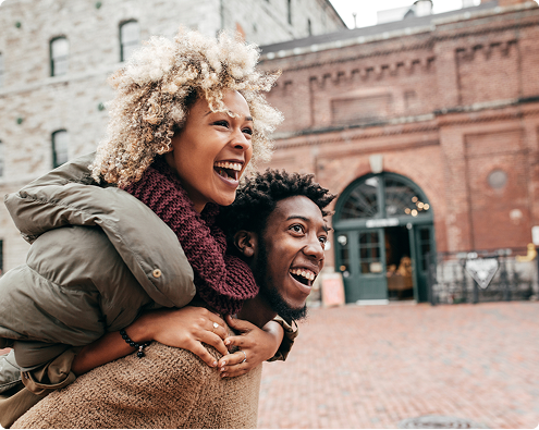 Two people laugh outdoors