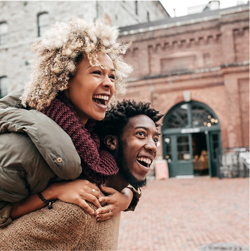 Two people laugh outdoors