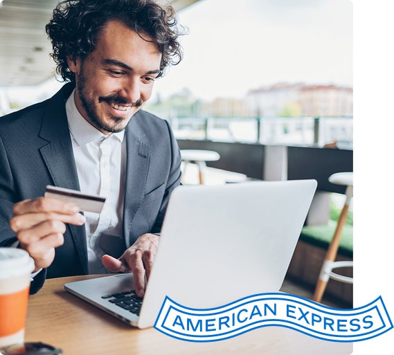 Person looks at laptop with card in hand