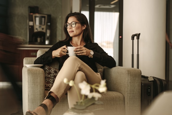 Woman enjoying a drink in a hotel lobby
