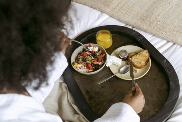 Woman enjoying breakfast in her hotel room