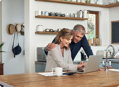 Two people at a counter, looking at a laptop