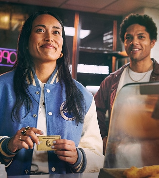 Person paying at restaurant with Amerian Express Gold Credit Card