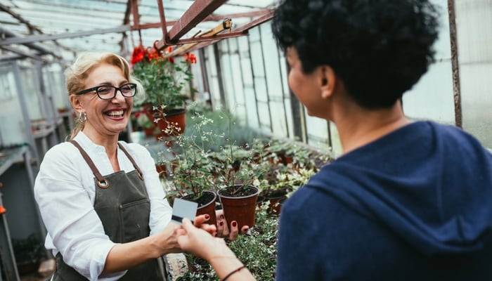 Woman working in a greenhouse nursery.