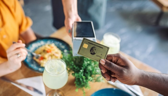 Two friends having lunch and paying with credit card.