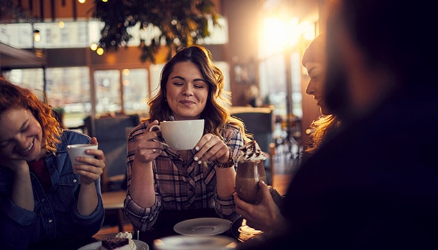 A group of women at a coffee shop laughing