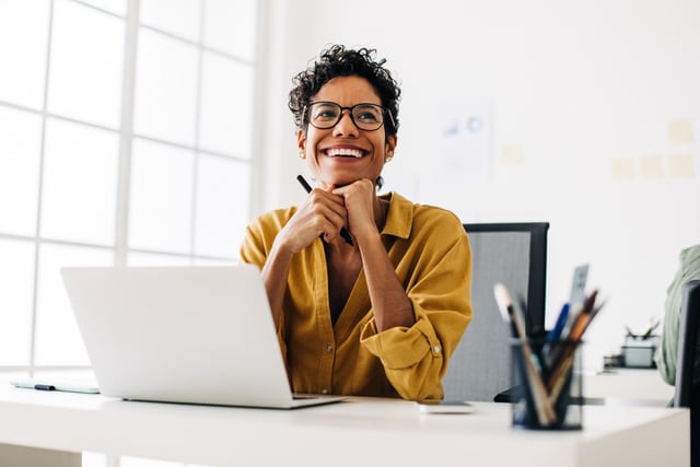 Creative woman working with a laptop and a stylus pen in an office.